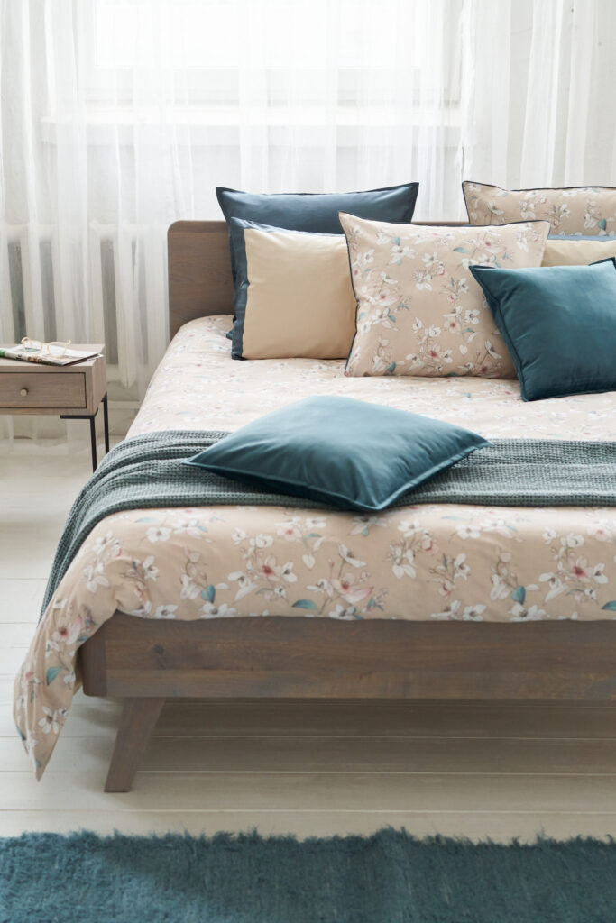 NOMO dekbedovertrek op bed, heel zachte bloemenprint in beige en teal.