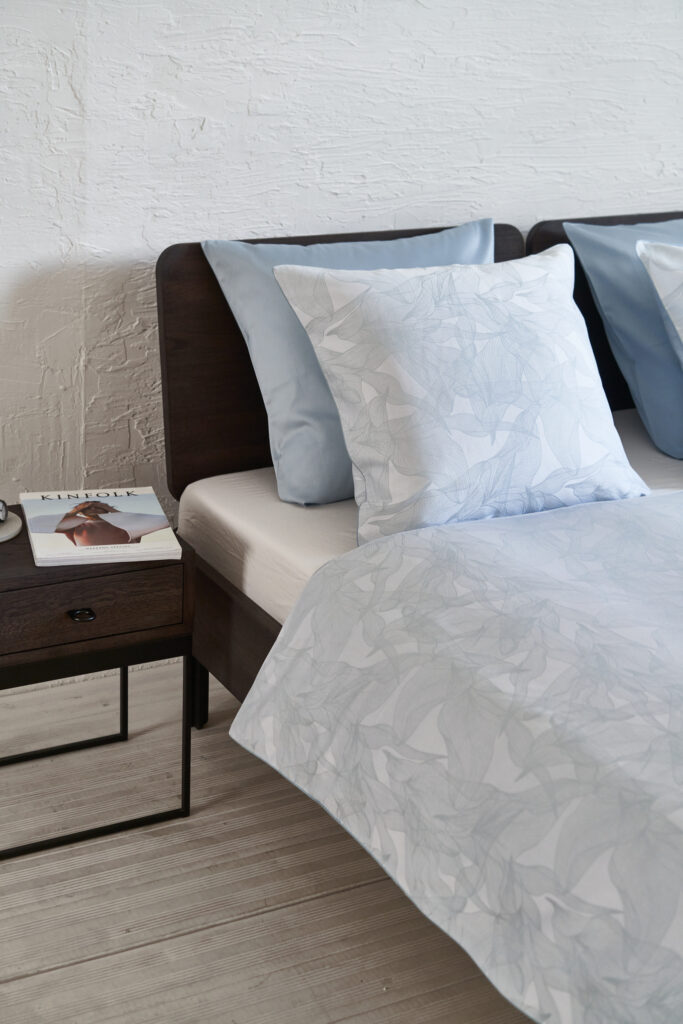 Foto van NOMO dekbedovertrek op bed in jacquard katoen, draadgeverfd met modern bloemen motief