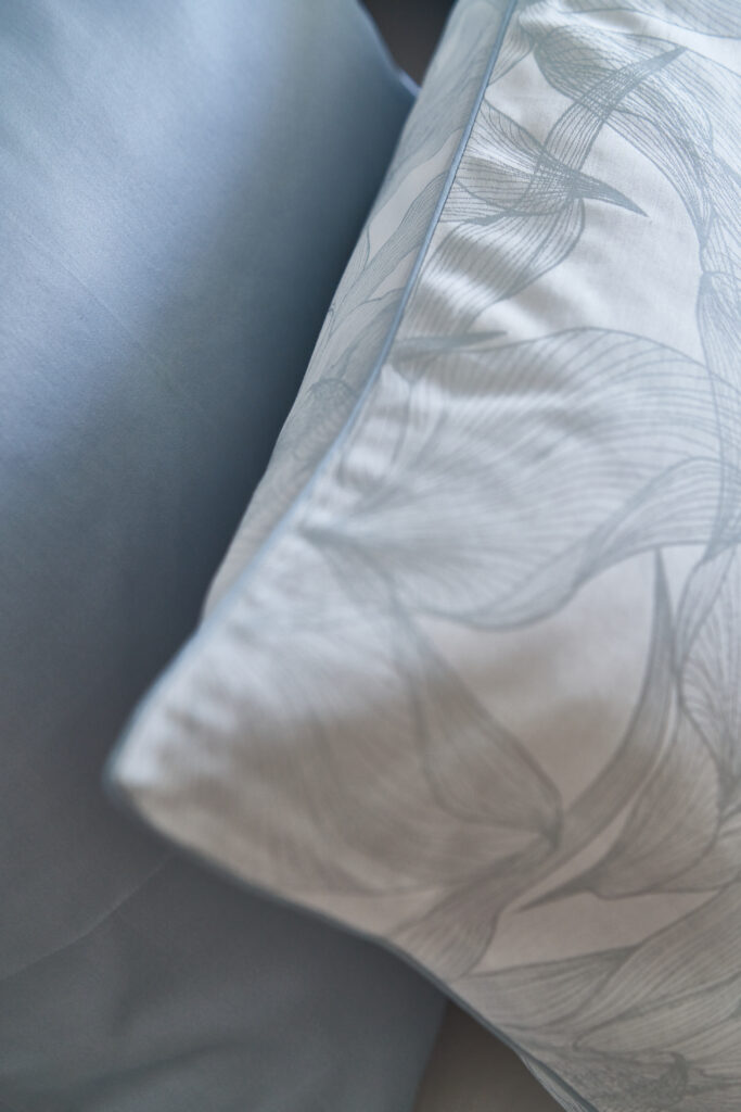 Foto van NOMO dekbedovertrek op bed in jacquard katoen, draadgeverfd met modern bloemen motief