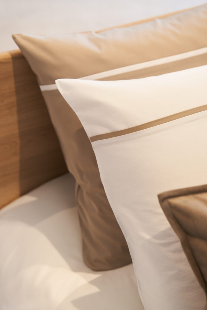 Foto van NOMO dekbedovertrek op bed in katoen satijn of katoen percale uni met gekleurde piping. Klassiek en tijdloos