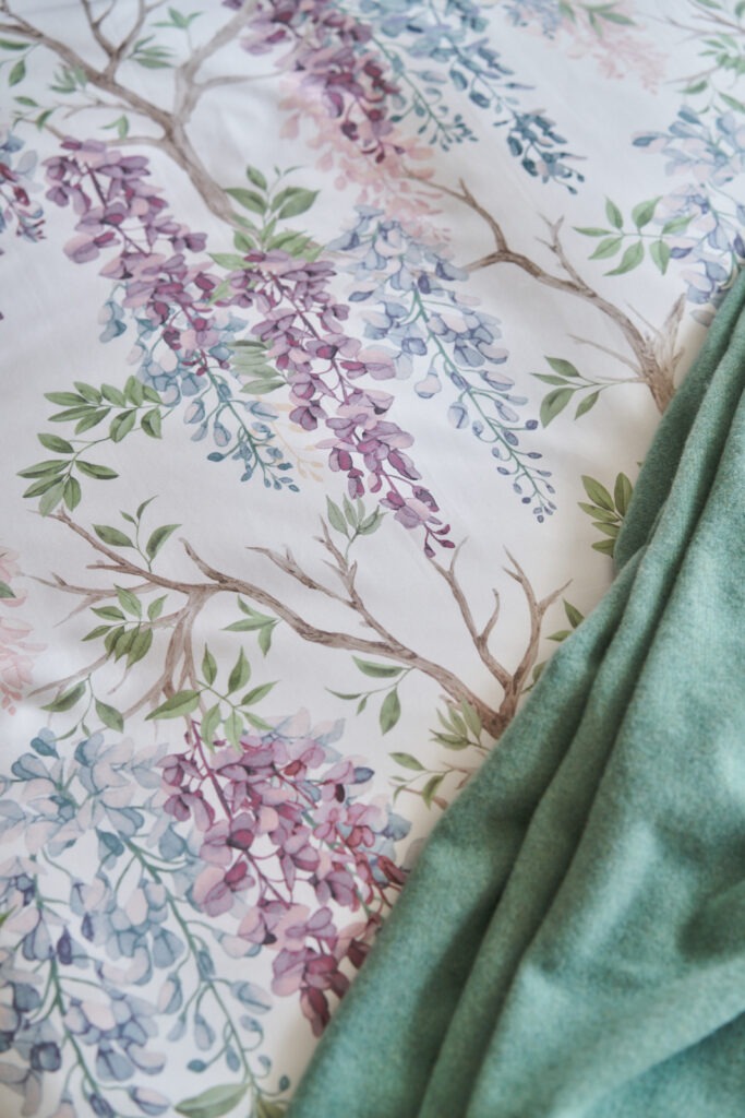 Foto van dekbedovertrek op bed in katoen satijn met print blauwe regen, in paars, blauw met takken